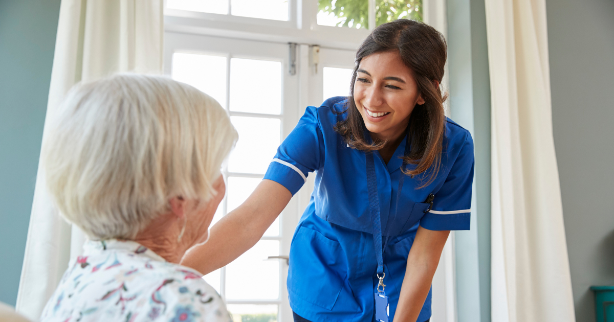 A woman enjoys her career in home health care as she cares for a senior patient.