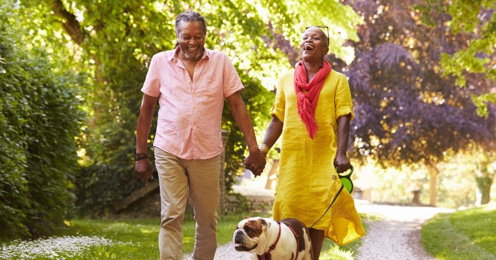 Walks, like this older couple and their dog are engaged in, are great activities for seniors in the springtime.