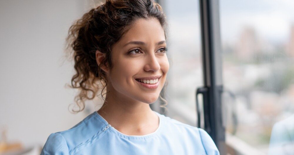 A caregiver smiles and looks hopeful, showing the kind of attitude that can help new professional caregivers