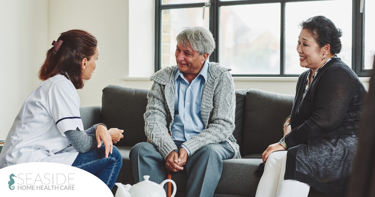 A caregiver talks with an elderly couple representing the kind of communication that professional caregivers need to have to anticipate client needs.