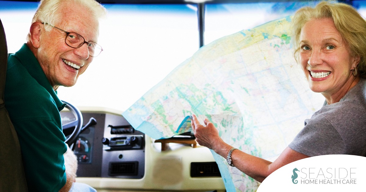 An older couple looks back smiling from the front of an RV, representing how day trips for seniors can help boost the mood of everyone.