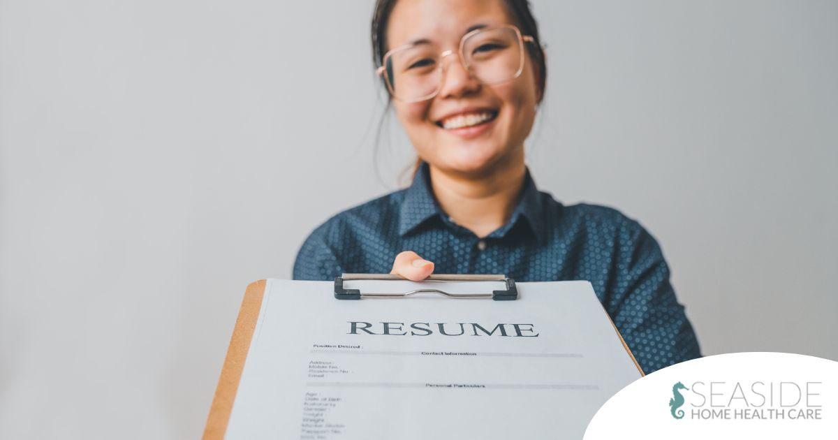 A woman happily hands in a resume, representing a successfully written caregiver resume.